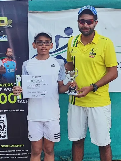 A young player receiving his runner-up trophy from coach Pulkit Mishra.