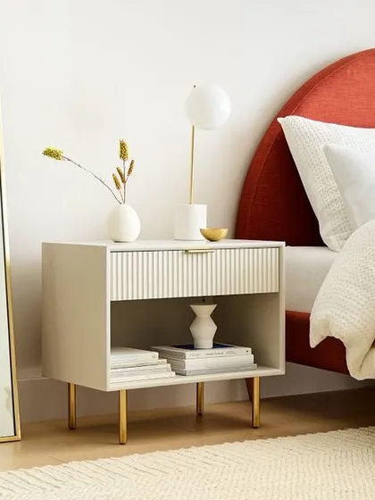 This modern nightstand features a roomy drawer with a fluted wood front and an open shelf for display. The lacquered finish and delicate metal legs add a touch of texture and shine to your bedside.