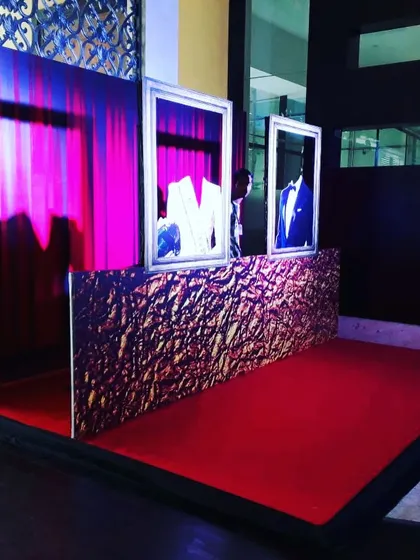 We design creative photo booths and displays for corporate events and product launches. This unique setup uses framed suits and dramatic lighting to create an eye-catching installation.