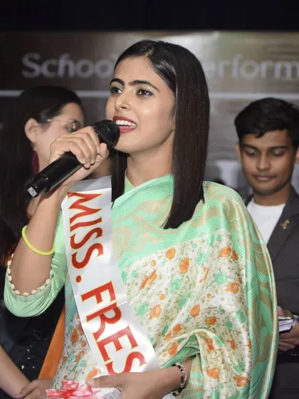 Capturing a key moment on stage as 'Miss Fresher' addresses the audience. These are the memorable highlights of any college event.