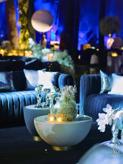A close-up of a table in the lounge area, with a simple yet elegant arrangement of baby's breath in a textured vase, surrounded by candles.