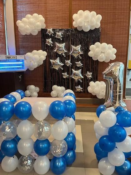 A sky-themed first birthday with blue and white balloon clouds and silver star foil balloons.