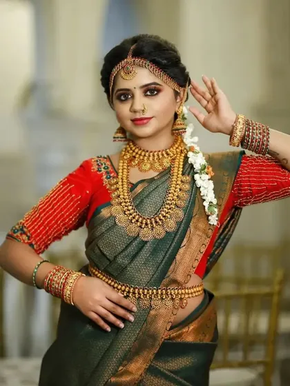 This model showcases a traditional look with a kasu malai set, complete with a matching vaddanam and jhumkas, perfect for a classic muhurtham.