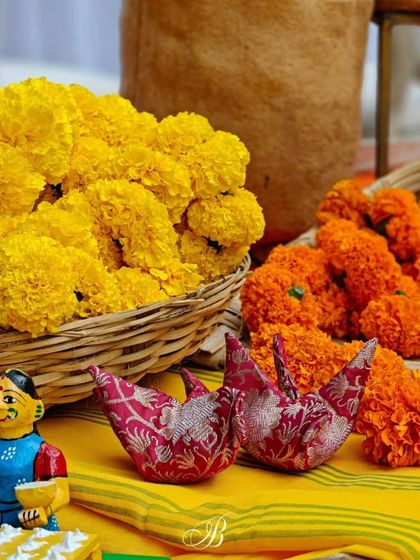 Whimsical origami birds crafted by an NGO from the bride's mother's old saree blouses, sitting amongst vibrant marigolds. This is a perfect example of combining sustainability, sentiment, and support for local artisans.