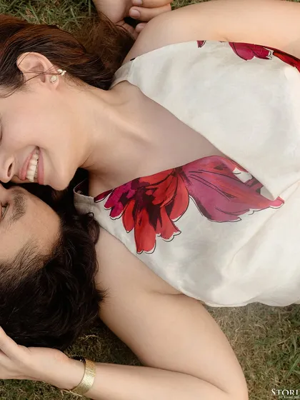 A close-up from above of the couple lying on the grass, sharing a moment of peace and happiness.