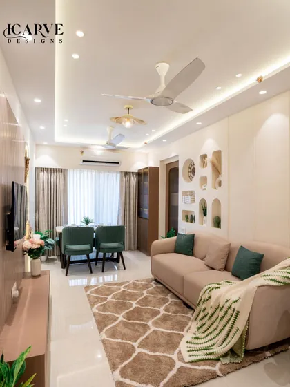 A look at a complete living and dining area we designed. We used a neutral color palette with pops of green, elegant cove lighting on the ceiling, and a mix of textures to create a space that feels both expansive and cozy.