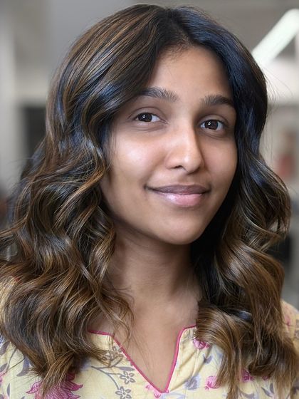 A happy client with her fresh, glowing balayage and soft waves.