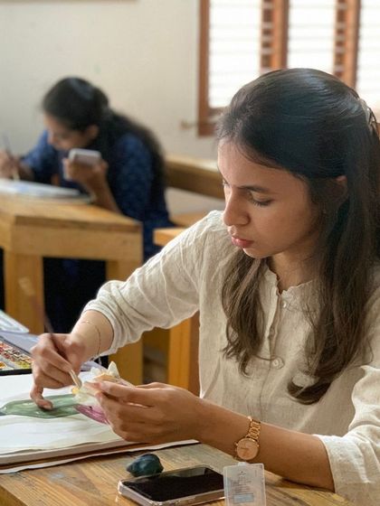 A student uses a palette knife to add texture to her painting. We encourage exploration of different tools and techniques to help you develop a versatile skill set.
