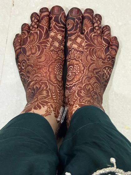A fully stained foot design, showing the intricate floral and paisley patterns that cover the entire foot.