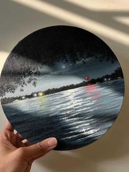 A moody and atmospheric nightscape painting of a lake on a round canvas. I focused on capturing the subtle reflections of distant lights and the moon on the dark water, creating a feeling of midnight calm.