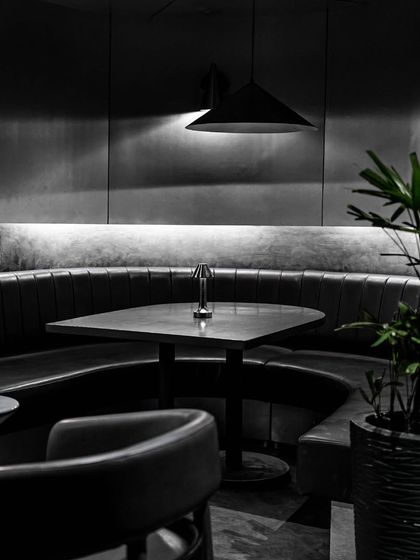 Step into a world of modern luxury and sophistication at our chic, monochromatic Lair. This view shows one of our comfortable booths, perfect for a relaxed evening.