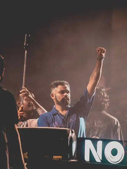 A powerful shot of me with one fist raised, a symbol of the driving, powerful energy of my techno sets.
