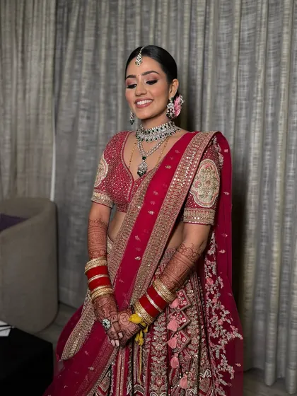 Anusha is all set to shine at her reception. We created the regal look she envisioned with matte eyes, glossy lips, and muted cheeks, perfectly complementing her stunning red outfit.