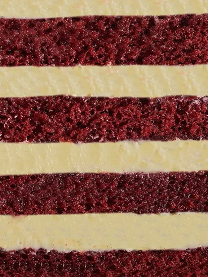 A close-up of the heart of my Red Velvet cake. You can see the distinct, soft layers of red velvet sponge alternating with smooth, tangy cream cheese frosting.