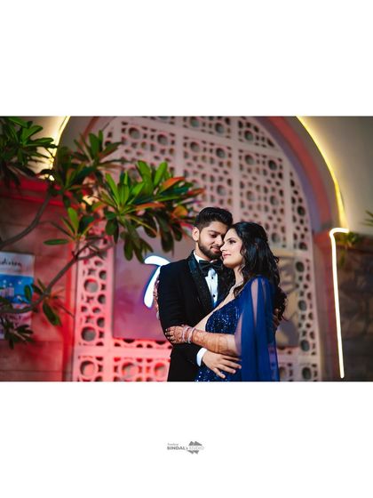 A romantic embrace against an elegantly lit backdrop. This shot captures the sophisticated and magical atmosphere of an evening celebration.