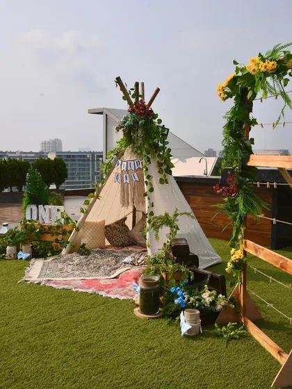 Another angle of the complete boho-themed first birthday setup, showing how all the different elements like the teepee, photo frame, and crate displays come together.