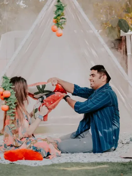 A fun pillow fight inside a beautifully decorated tent setup. This shows a playful and intimate side of our pre-wedding photography sessions.