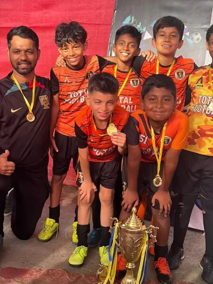 Our U11 champions from the Andheri Premier League, celebrating with their coach and trophy.