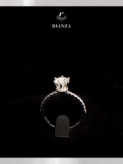 Another view of the solitaire ring with a hidden halo, showcasing the delicate diamond-studded band and the beautifully raised setting of the central stone.