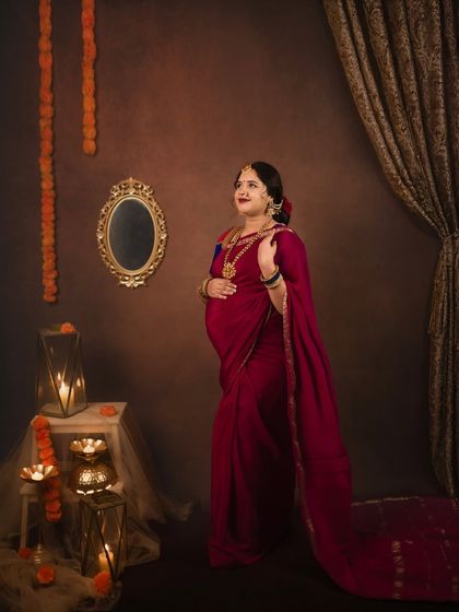 A solo portrait of the mom to be, looking elegant and thoughtful. The warm, festive decor with diyas and marigolds adds to the traditional charm.