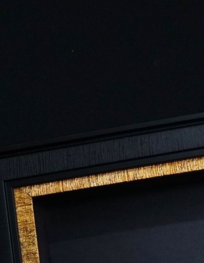 The frame itself is an important part of the design. This close-up shows the texture of a classic black frame with a distressed gold inner border, which adds a touch of vintage elegance.