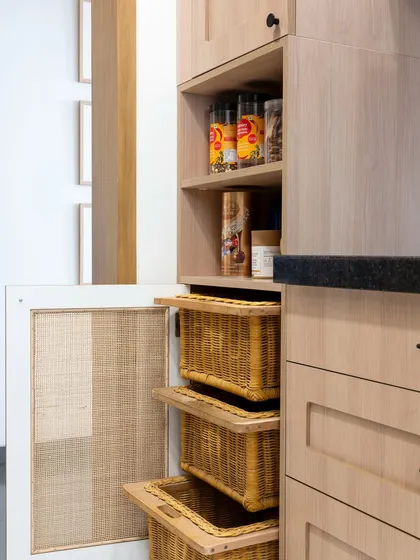 This pantry unit combines open shelving for easy access with pull-out wicker baskets for storing produce. It’s a perfect example of how we blend different storage types to meet our clients' specific needs.