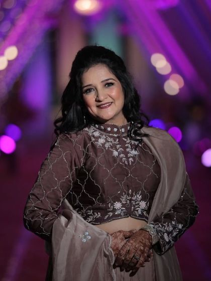 A happy and radiant shot of the bride's mom, ready to dance the night away at the Sangeet. The makeup is designed to be long-lasting and photograph beautifully.