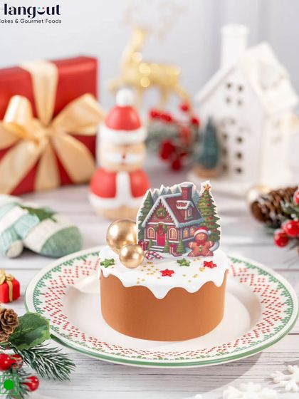 A charming Christmas Dutch Truffle Bento Cake, decorated with an edible winter cottage scene. The rich chocolate sponge and smooth ganache make it a perfect treat for spreading Christmas cheer.