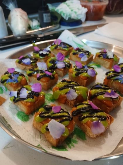 A tray of the toast-based canapés, garnished with edible flowers. I believe in making every dish, no matter how small, a visual delight.