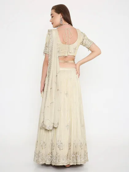The back of our ivory lehenga showcases a charming tie-back blouse and the graceful fall of the fabric. Every detail is considered to ensure you look perfect from every angle.