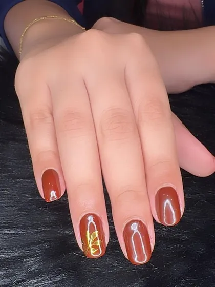 Autumn feels with this warm, rusty brown polish and a simple gold chrome accent.