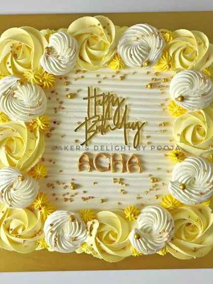 This elegant yellow sheet cake was part of a set of three for a joint 70th and 80th milestone birthday celebration. The piped rosettes and meringue kisses add a classic touch.