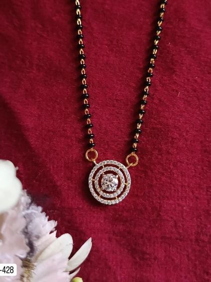 This classic mangalsutra design features a solitaire-style American diamond in a double halo setting. It's a timeless and elegant piece for daily wear.