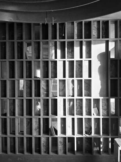 A behind-the-scenes shot of the grid wall during construction. This black and white photo captures the meticulous craftsmanship that goes into creating such a detailed interior feature.