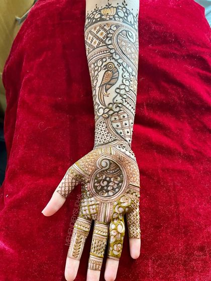 A single-hand view of the parrot engagement mehendi, showing the detail in the bird and the surrounding patterns.