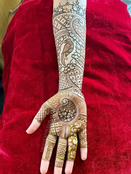 A single-hand view of the parrot engagement mehendi, showing the detail in the bird and the surrounding patterns.