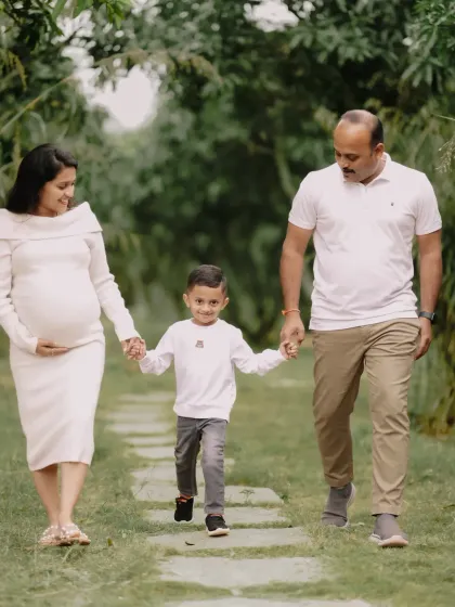 A family strolls together, hand in hand, on the cusp of welcoming a new member. I focus on capturing these natural interactions, showing the bond between parents and the excitement of an older sibling, making for an honest family maternity portrait.