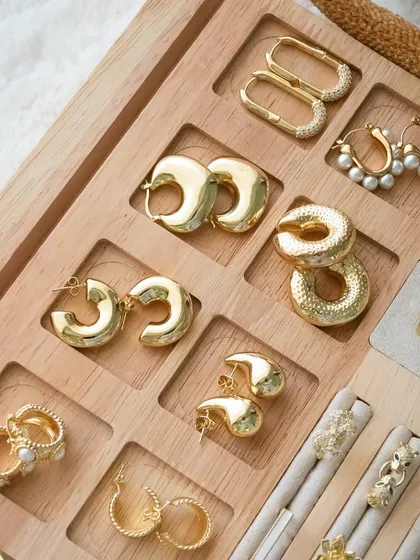 Accessorize like you mean it. This wooden tray is filled with our best-selling earrings and rings, showing the quality and style of our collection.