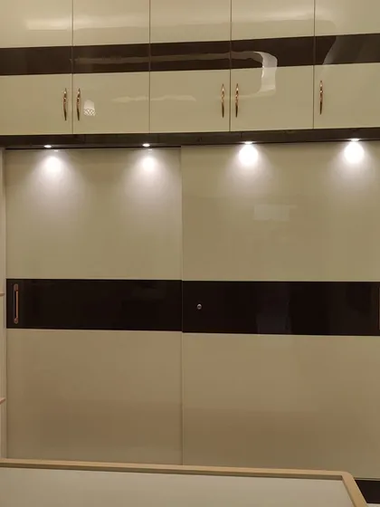 A modern bedroom deserves a modern finish. We gave this wardrobe a sleek, high-gloss Duco finish, combining classic white with a dark wood-tone band. The reflective surface adds a touch of luxury and makes the room feel brighter and more spacious.