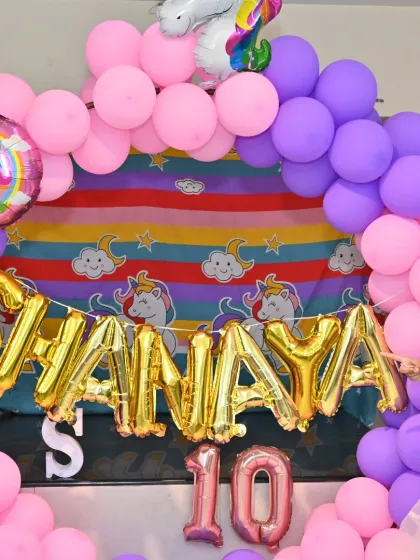 A detailed shot of the personalized name banner and themed backdrop for the Unicorn party.