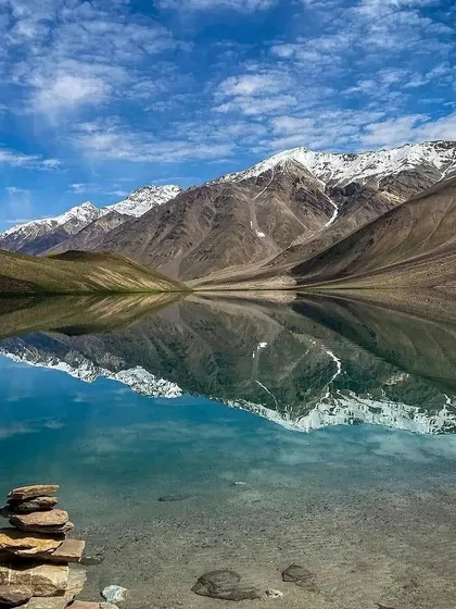 The stunning Chandratal Lake, also known as the Moon Lake, with its perfect reflection of the snow-capped mountains. This is a highlight of our Hampta Pass trek.