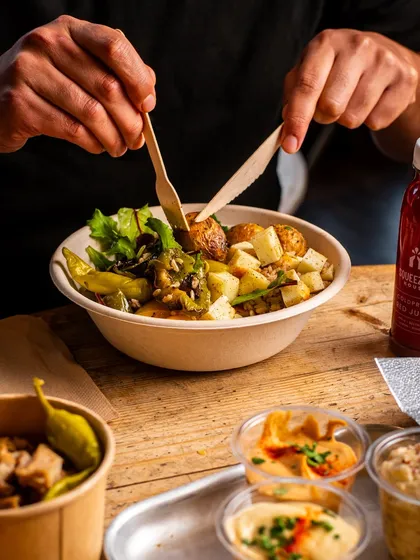 A customer digging into a healthy bowl. This action shot makes the food look more engaging and delicious.