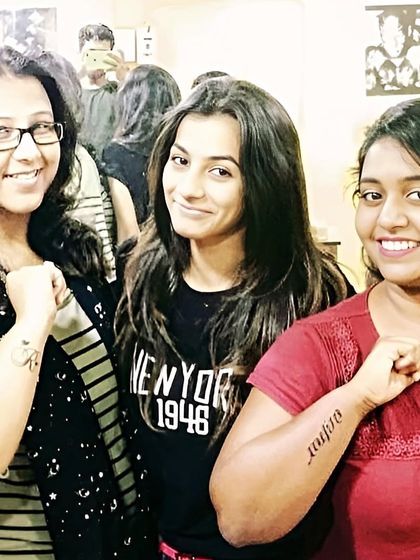 Friends showing their new tattoos together at the studio.