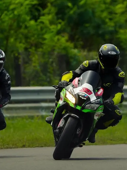 A Kawasaki ZX-10R leads a BMW S1000RR in a friendly on-track battle, showcasing the variety of superbikes at our events.