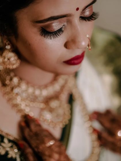 A beautiful close-up of a bride, looking down at her intricate gold jewelry. The soft focus creates a dreamy and romantic portrait.