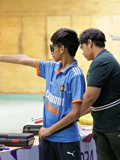 Guidance is key. Here, one of our coaches provides hands-on instruction to a young pistol shooter, ensuring he develops the correct form and technique right from the start. We are dedicated to nurturing young talent for India.