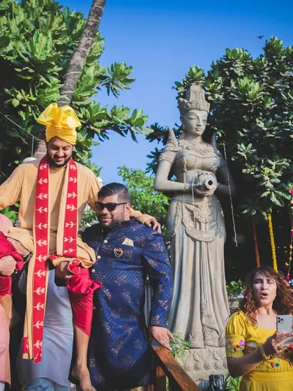 The groom being carried by his friends, a fun and chaotic moment during the baraat. We capture the energy and excitement of the groom's procession.