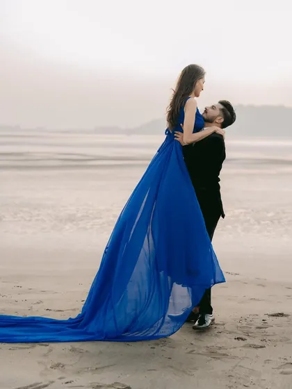 Lost in the moment, and in your arms. This flowing blue gown adds a touch of romance and movement to this beautiful beach pre-wedding photograph.