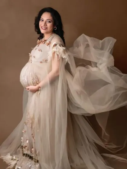 The sheer cape of this beige gown creates a beautiful, flowing effect, adding a touch of ethereal grace to a fitted silhouette.