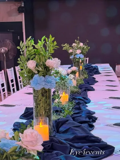 This shot highlights the repeating pattern of floral vases and candles that creates a sense of rhythm and grandeur along the length of the dining table. It's a key element in our formal event design.